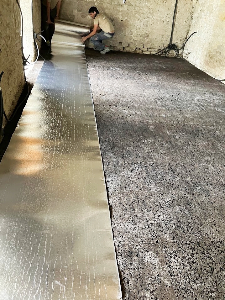 Instalación de aislamiento de corcho expandido en el suelo antes de colocar el suelo radiante.